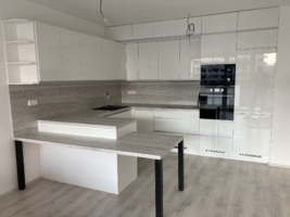 Minimalisticky ře&scaron;en&aacute; kuchyň se zakomponovan&yacute;m stolem