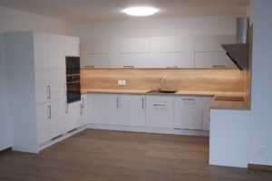 Kuchyň se zv&yacute;&scaron;en&yacute;m obkladem po horn&iacute; hranu skř&iacute;něk